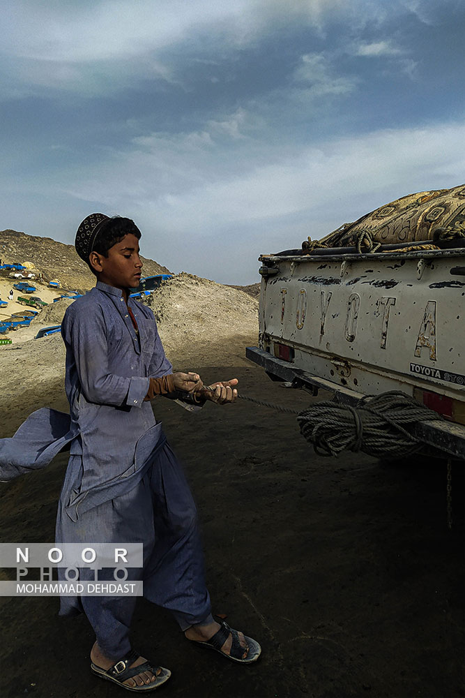 شهاب ۱۲ ساله اصالتا اهل پاکستان بعنوان کمک راننده در مرز ایران و پاکستان در حال کار است
